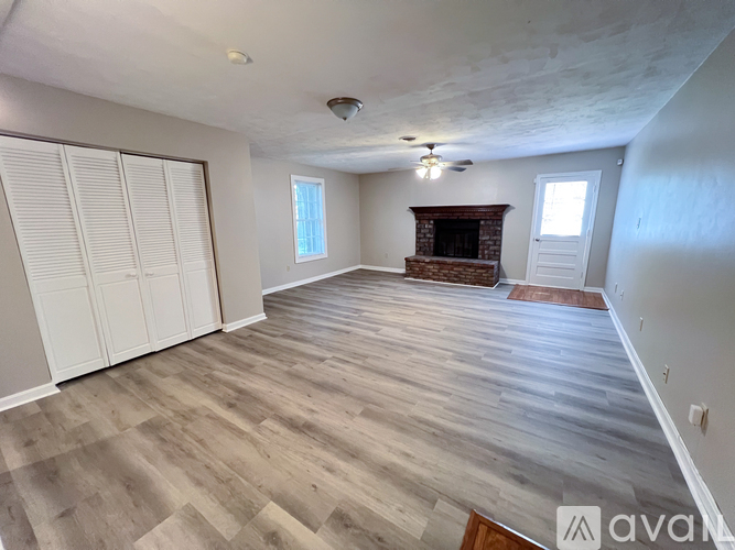 A spacious room with a fireplace and sliding doors.