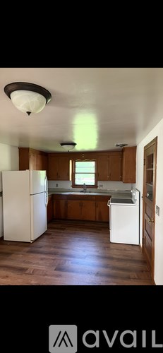 A kitchen with wooden cabinets and a white refrigerator.