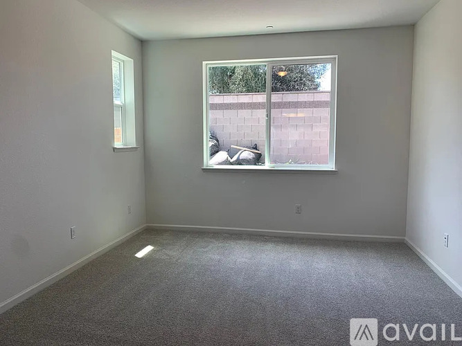 A room with a window showing a car and a building outside.
