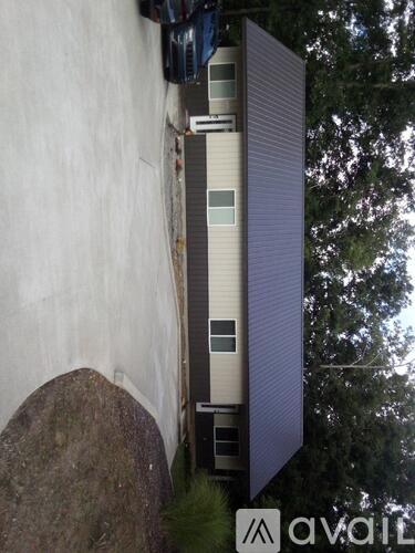 A modern house with a white exterior and a large window is shown.