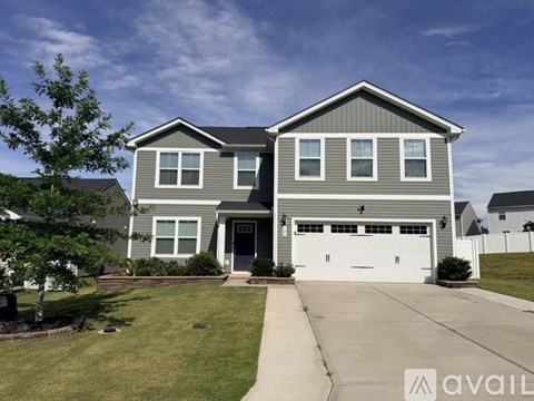 A two-story house with a garage is available for sale.