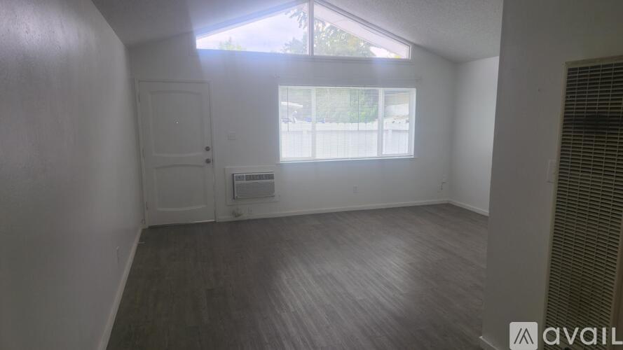 A room with a window and a door is available for rent.