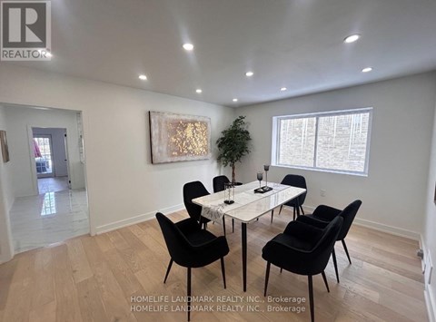 A dining room with a white table and black chairs.
