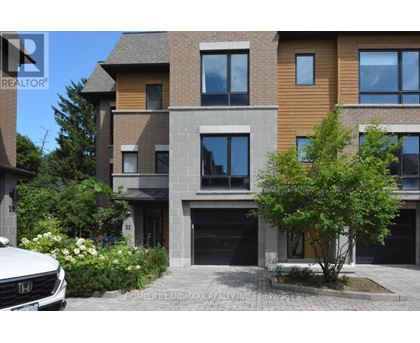 A modern two-story house with a garage and a tree in front.
