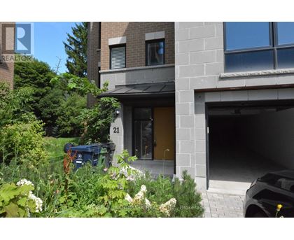 A modern house with a garage and a garden in front.