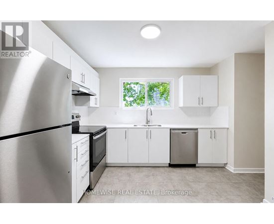 A kitchen with white cabinets and a stainless steel refrigerator.