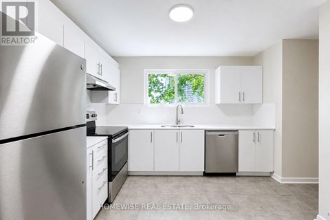 A kitchen with white cabinets and a stainless steel refrigerator.