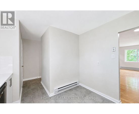 A white bedroom with a window and a door.