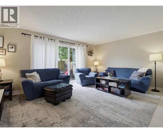 A living room with blue furniture and a grey rug.