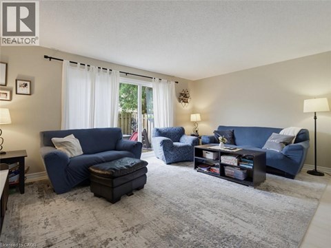 A living room with blue furniture and a grey rug.