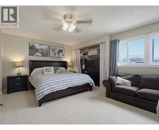 A bedroom with a large bed and a couch.