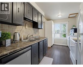 A kitchen with black cabinets and a white refrigerator.
