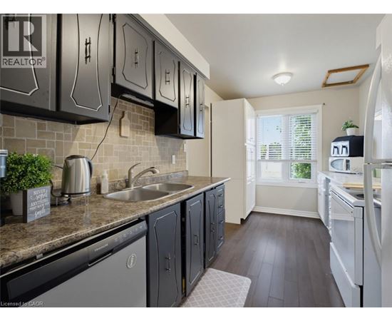 A kitchen with black cabinets and a white refrigerator.