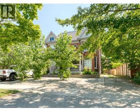 A house with a white picket fence is surrounded by trees.