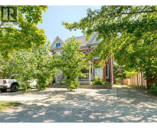 A house with a white picket fence is surrounded by trees.