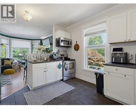 A kitchen with white cabinets and a black countertop.
