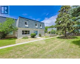A house with a lawn and a tree in front of it.