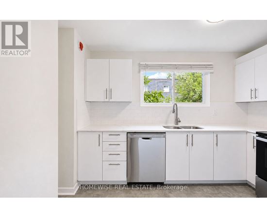 A white kitchen with a sink and cabinets.