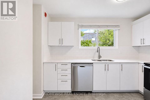 A white kitchen with a sink and cabinets.