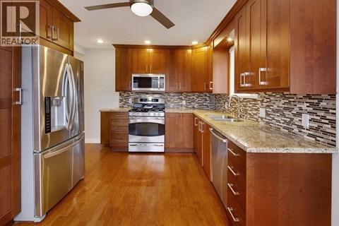 A kitchen with wooden cabinets and a stainless steel refrigerator.