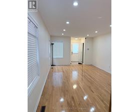 A room with wooden flooring and white walls.