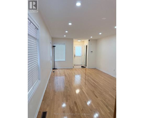 A room with wooden flooring and white walls.