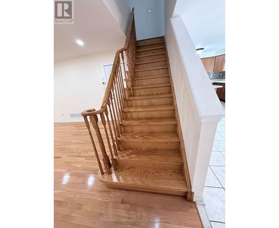 A wooden staircase with a white railing.
