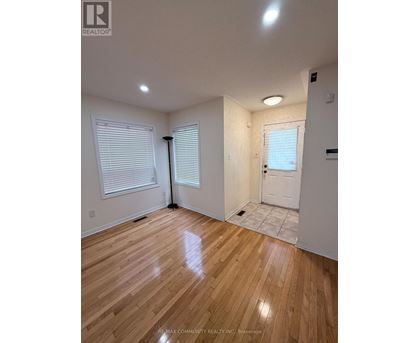 A room with wooden flooring and white walls.
