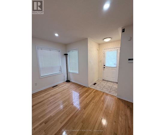 A room with wooden flooring and white walls.