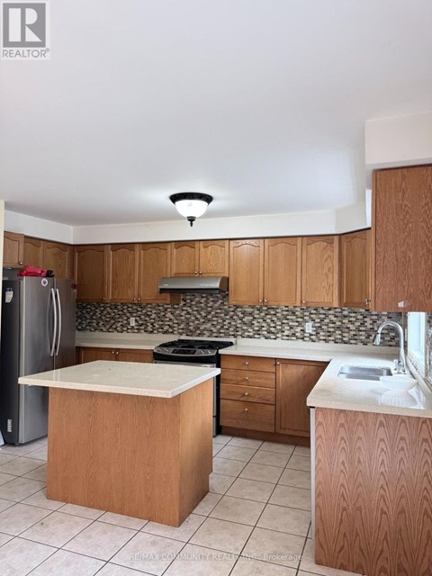 A kitchen with wooden cabinets and a white counter top.