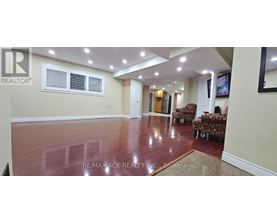 A spacious room with a polished floor and a large window.
