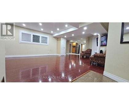 A spacious room with a polished floor and a large window.