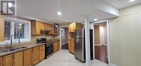 A kitchen with wooden cabinets and a black stove top oven.