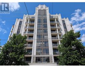 A tall residential building with balconies and a clear sky above.