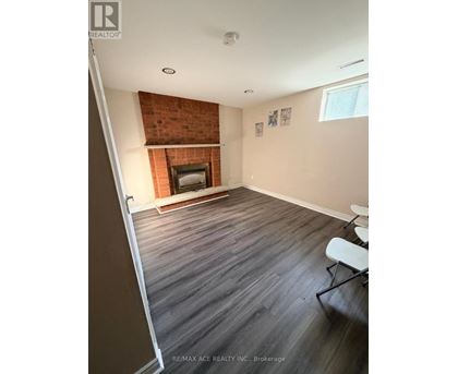A room with a fireplace and wood flooring.