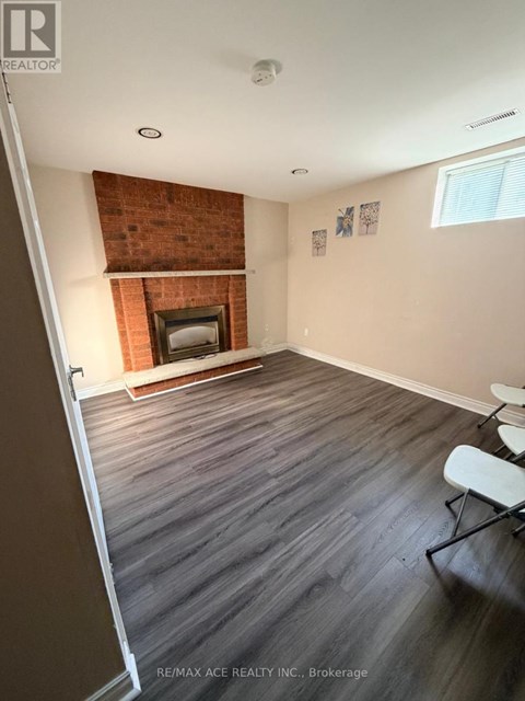 A room with a fireplace and wood flooring.