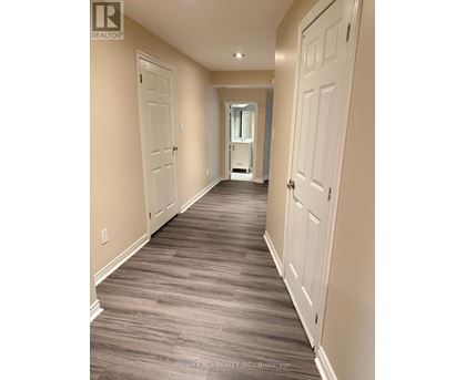 A hallway with wood flooring and white doors.