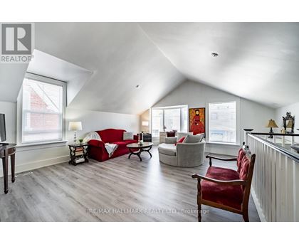 A living room with a red couch and a wooden floor.