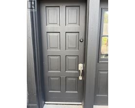 A grey door with a keyhole and a key in it.
