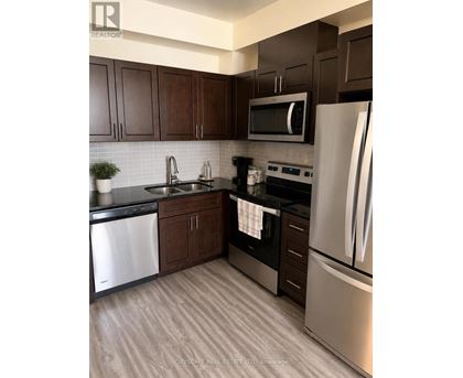 A kitchen with dark brown cabinets and stainless steel appliances.