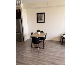 A dining room with a wooden table and chairs.