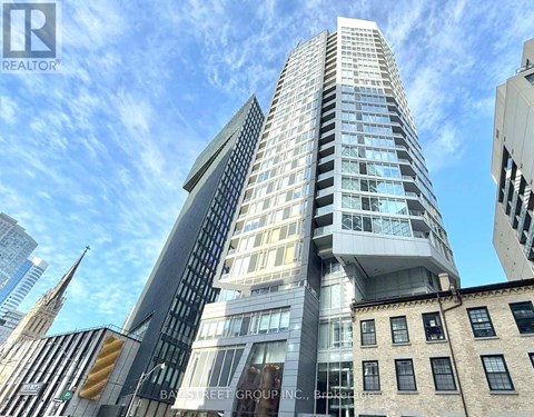 A tall, modern building with many windows is the focal point of the image.