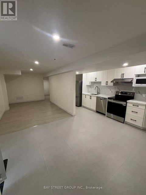 A spacious kitchen with white cabinets and appliances.