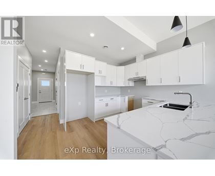 A kitchen with white cabinets and a marble countertop.