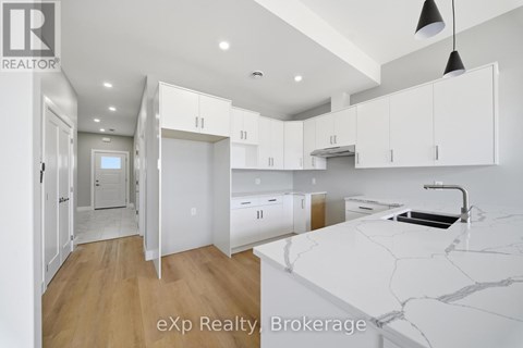 A kitchen with white cabinets and a marble countertop.