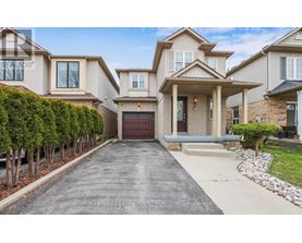 A large, well-maintained house with a driveway in front.