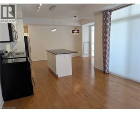 A kitchen area with a refrigerator, cabinets, and a countertop.