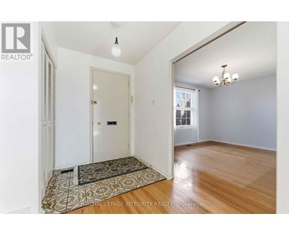 A room with a rug on the floor and a door in the background.