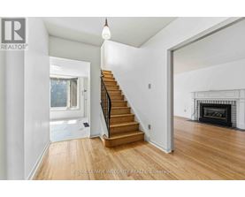 A spacious room with a staircase leading to the upper floor.
