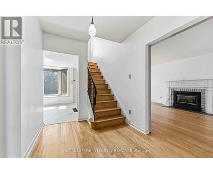 A spacious room with a staircase leading to the upper floor.